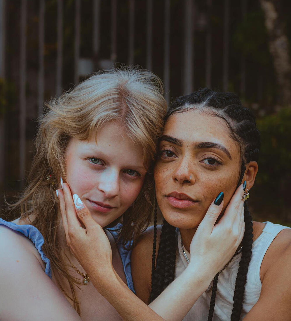 Girls smiling with their heads together.
